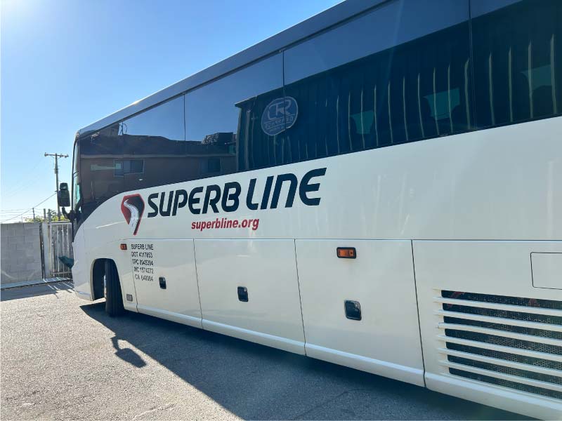 A modern charter bus in merced, ca driving along a scenic California highway, showcasing safe and reliable group transportation with our california charter bus  services